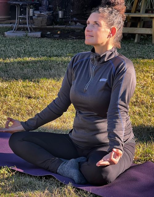 A woman with short hair enjoys reading magazines while listening to music indoors.